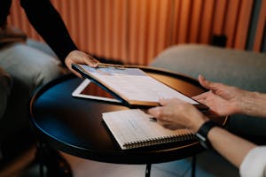 Business professionals exchanging resume during meeting, focusing on career advancement.